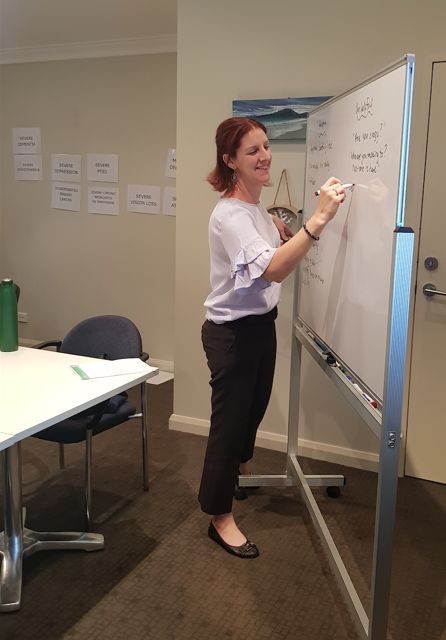 Amanda Oliver writing on a whiteboard during a training session